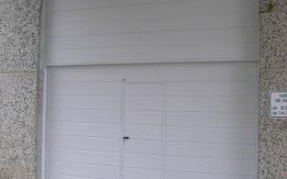 Puerta contrapesada de dos hojas de apertura vertical, en panel sándwich blanco