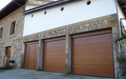 Grupo de puertas seccionales imitación madera y puerta peatonal integrada